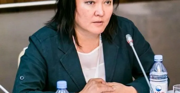 A woman is sitting at a table in front of a mic
