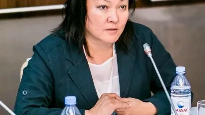 A woman is sitting at a table in front of a mic