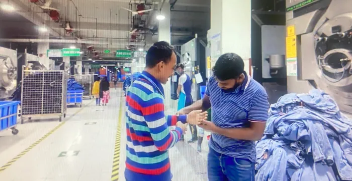 A man shows his colleague his new prosthetic arm at a garment factory in Bangladesh